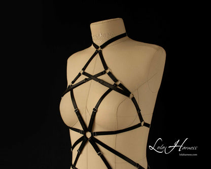 Close-up of black choker harness bodysuit chest part with silver rings.