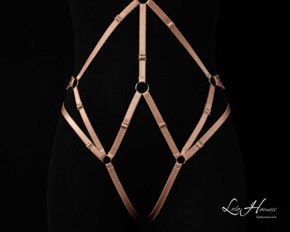 Close-up front bottom view of The Carry harness playsuit on a mannequin in dusty rose, highlighting the crotchless design.