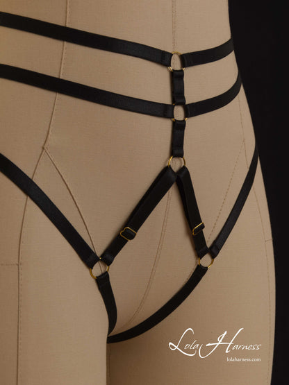 Close-up of the front view of The Darlene harness panties on a mannequin in black, detailing the open crotch design and adjustable straps.